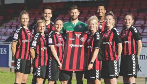 Lewes Football Club's men's and women's side pose with their home shirt.