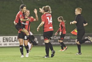 Lewes women's side celebrate a goal being scored.